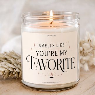 Smells Like You’re My Favorite 9 oz soy candle with elegant black typography, cream background, small flame icon, and star accents for a funny favorite person gift